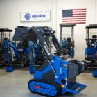 Rippa RS04 skid steer mini excavator side view with raised bucket inside Portland Oregon warehouse